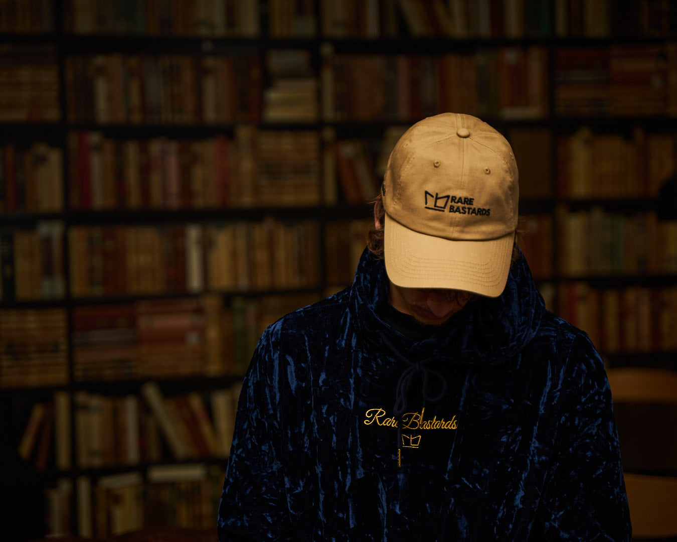 Man wearing a blue hoodie and a beige cap.