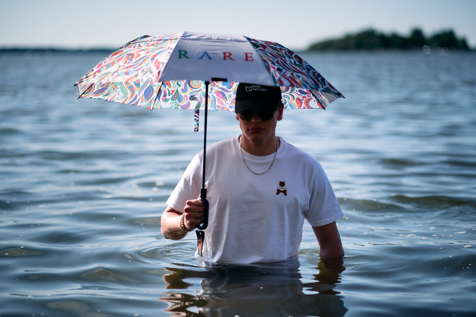 Person holding a colorful umbrella with 'RARE' branding underwater